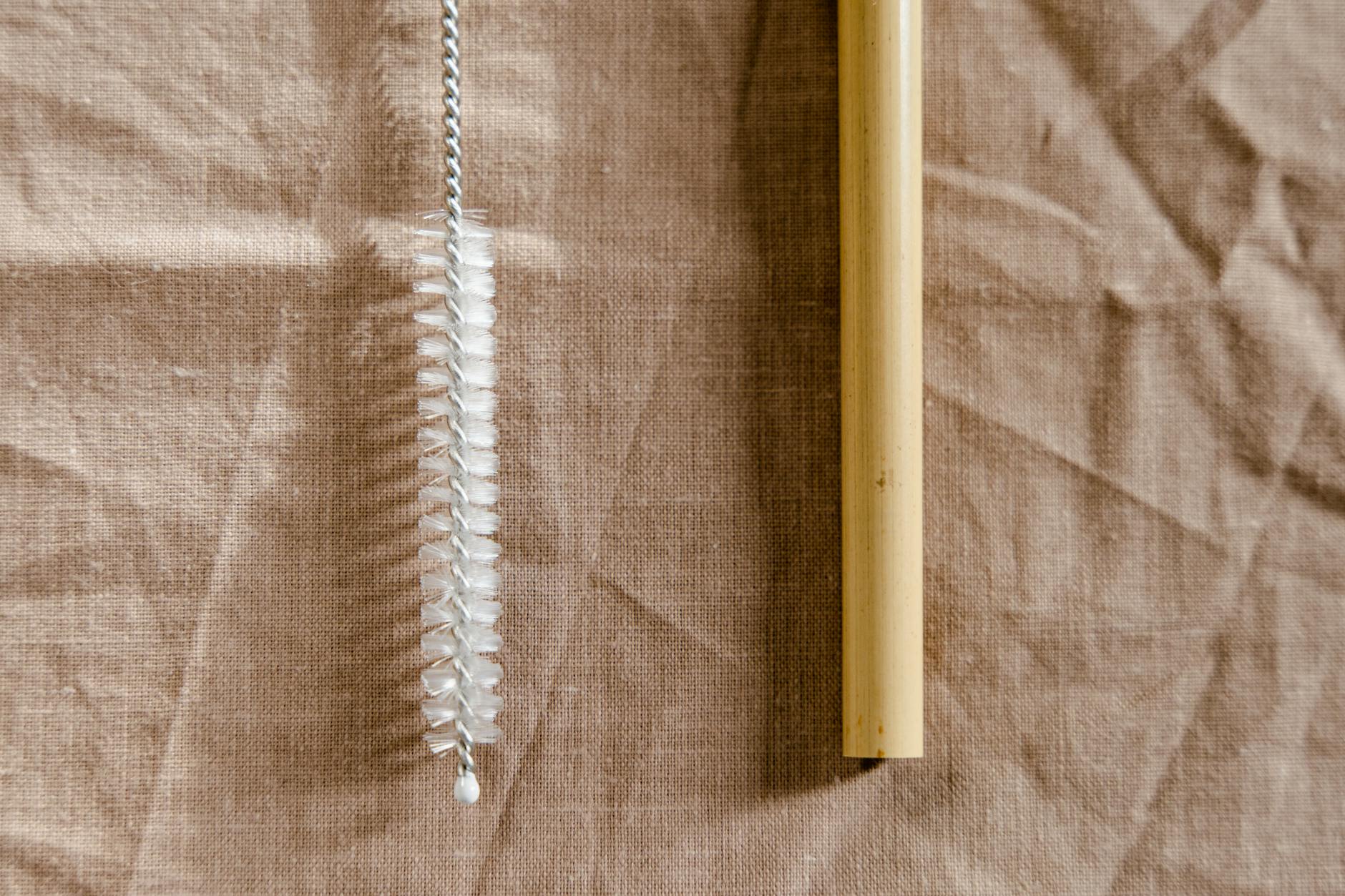 close up of a bamboo straw and a cleaning brush